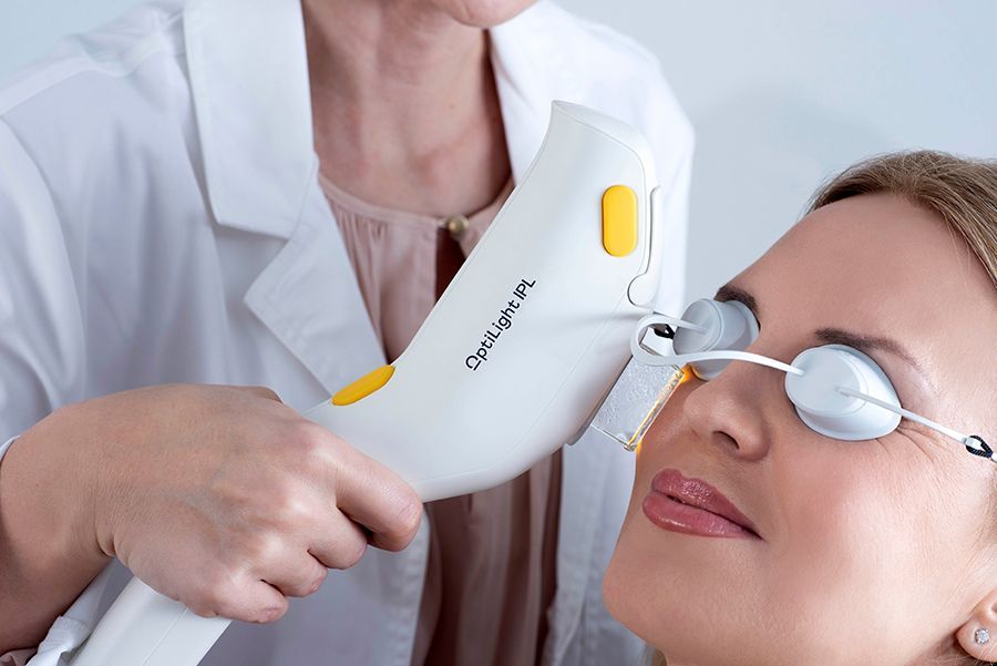 Eye treatment with handheld laser device on a patient wearing protective goggles