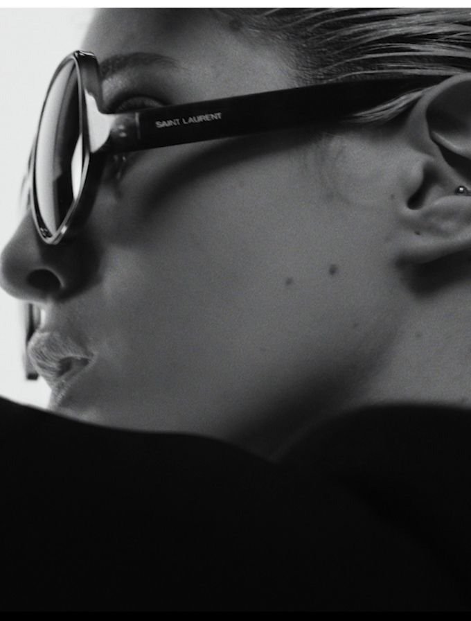 Black-and-white close-up profile of a person wearing sunglasses, face turned left.