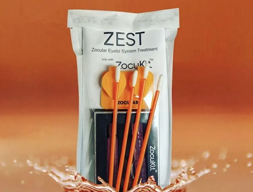 ZEST paste packet with orange toothbrushes on an orange background, splashing water at the bottom