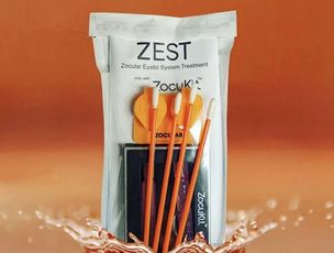 ZEST paste packet with orange toothbrushes on an orange background, splashing water at the bottom
