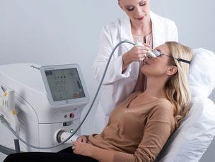 Clinician treating a patient with a laser device in a medical office