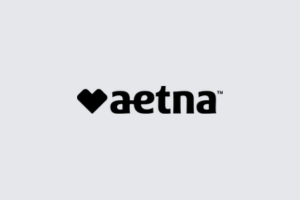 Aetna logo with black heart icon and wordmark on a light gray background