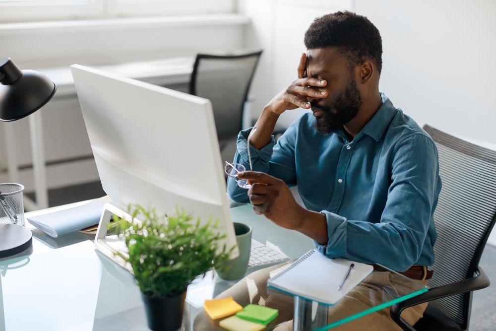 man with dry eyes working on computer - low level light therapy