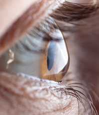 Close-up of a human eye with a blue-gray iris and visible eyelashes
