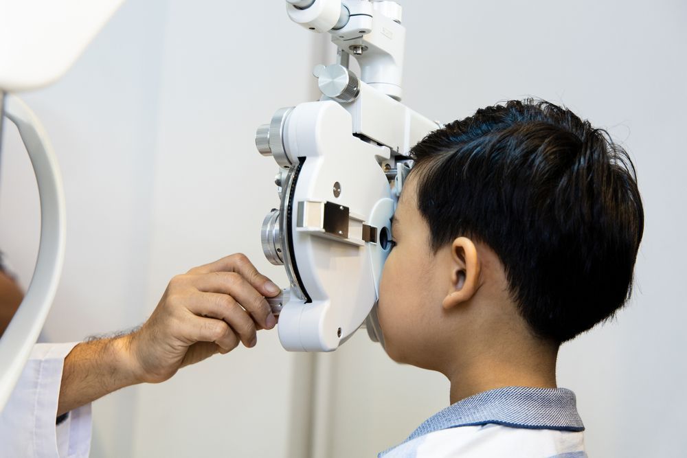 Eye exam in progress as an optometrist adjusts a phoropter for a patient in a clinic