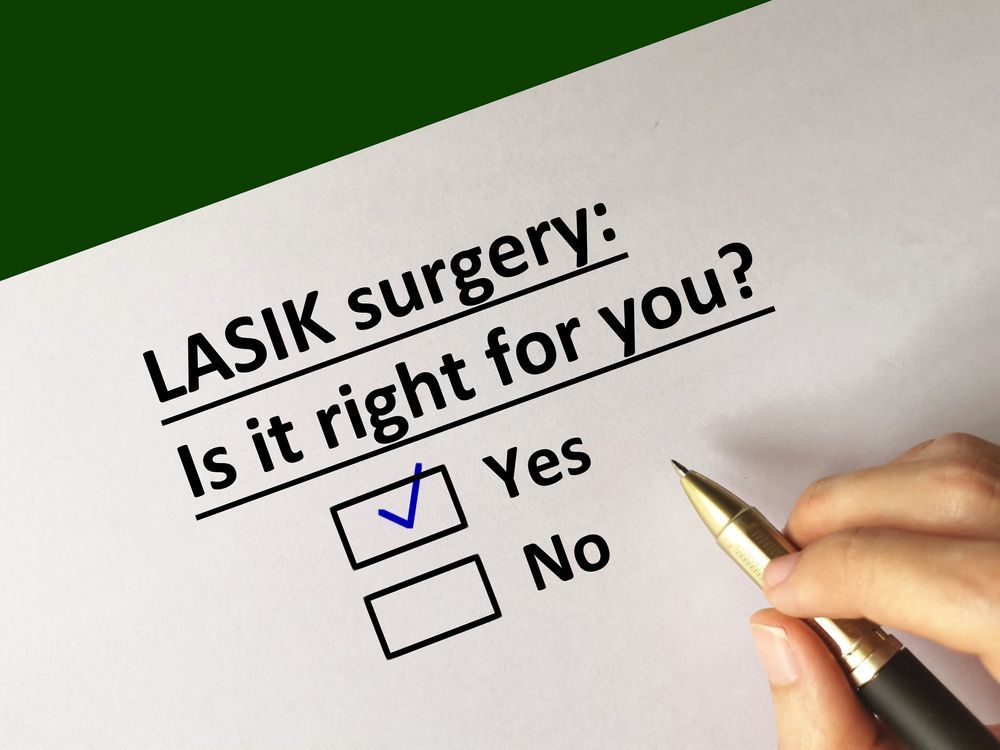 LASIK surgery form with “Is it right for you?” and checkboxes; hand holding a pen beside it