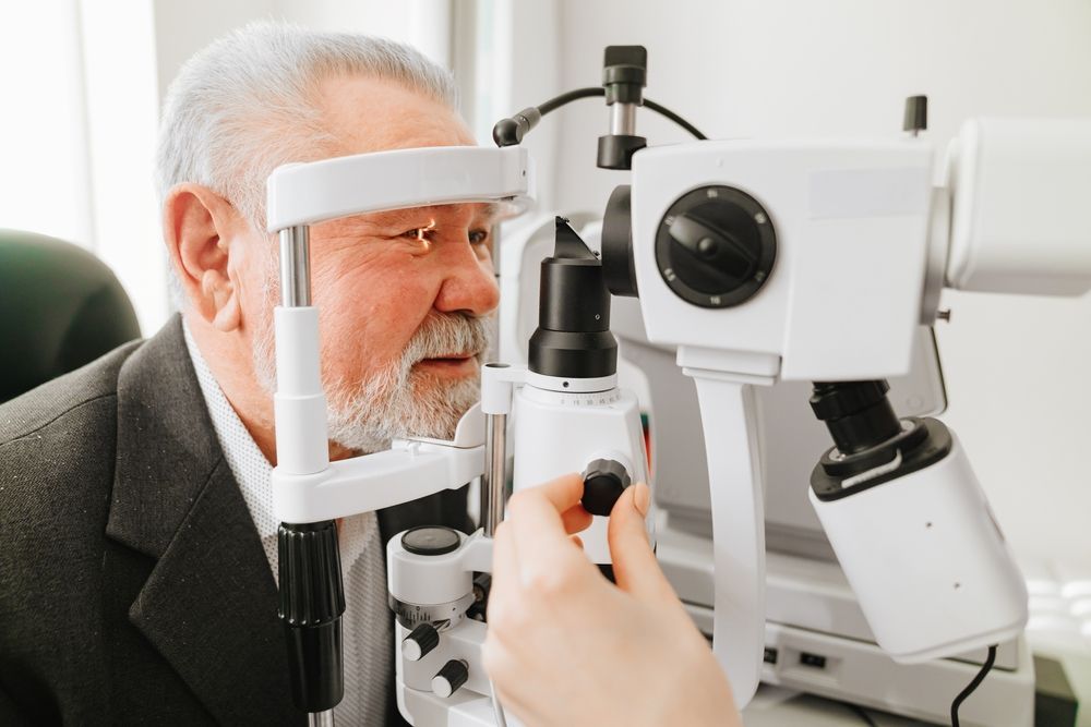 Eye exam with a patient using a phoropter and ophthalmic imaging device