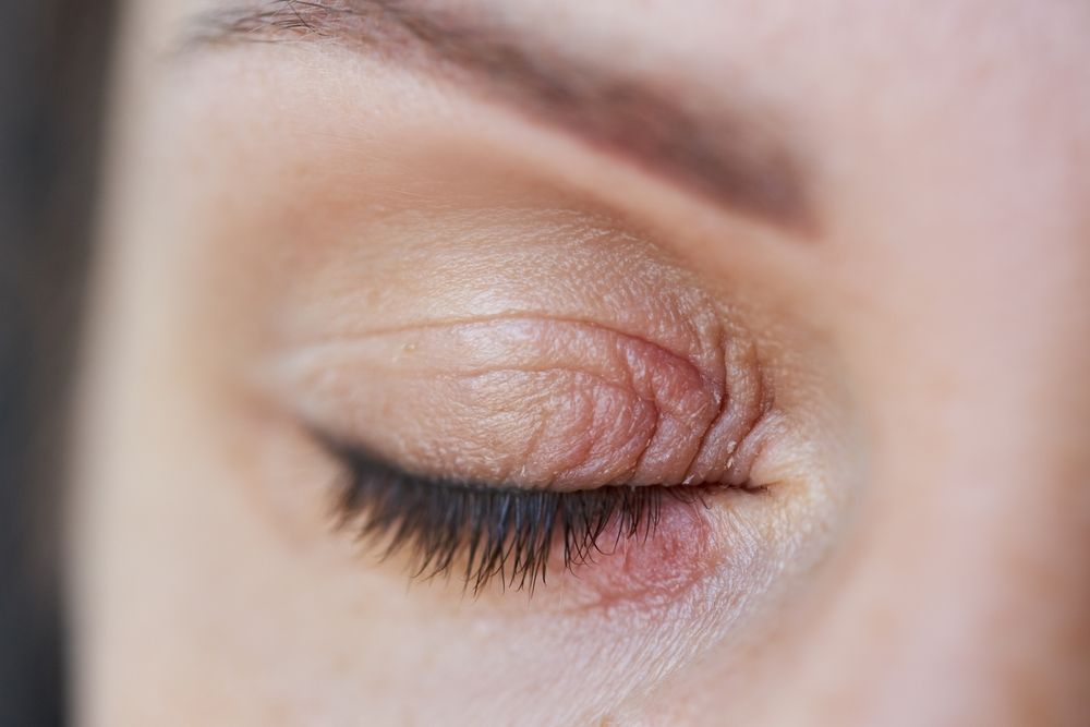 Close-up of a closed eye with gold eye shadow and long eyelashes