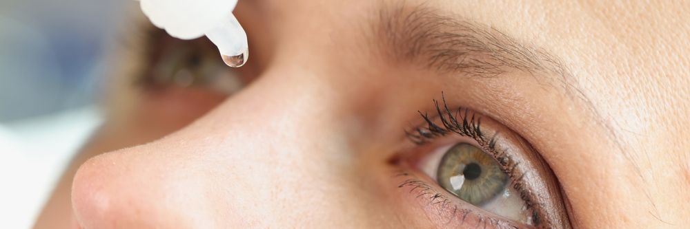 Eye being treated with eye drops from a dropper close-up
