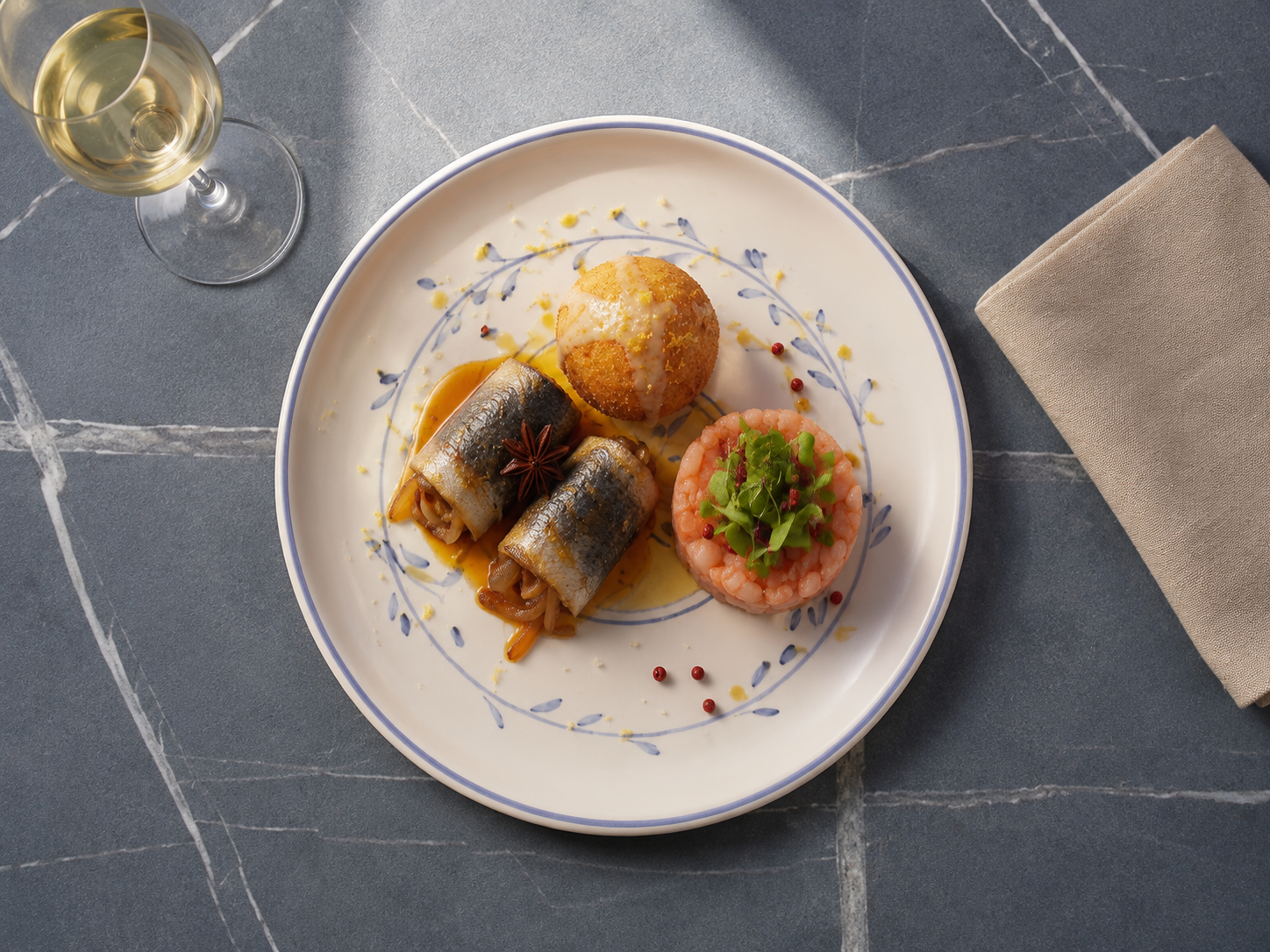 Piatto gourmet con pesce, patate arrosto e verdure, accompagnato da un bicchiere di vino bianco.