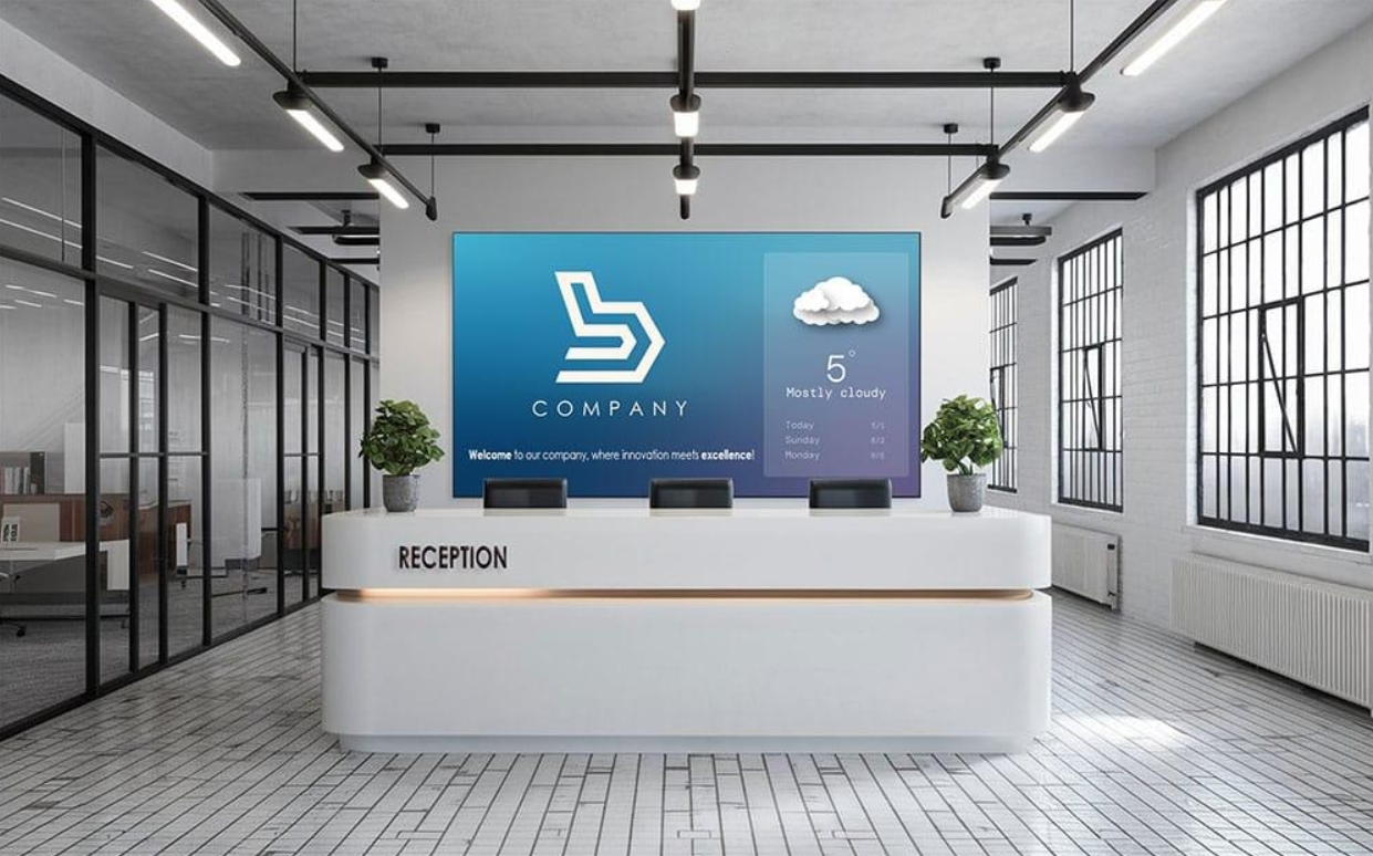 Modern office lobby with white reception desk and blue corporate wall display