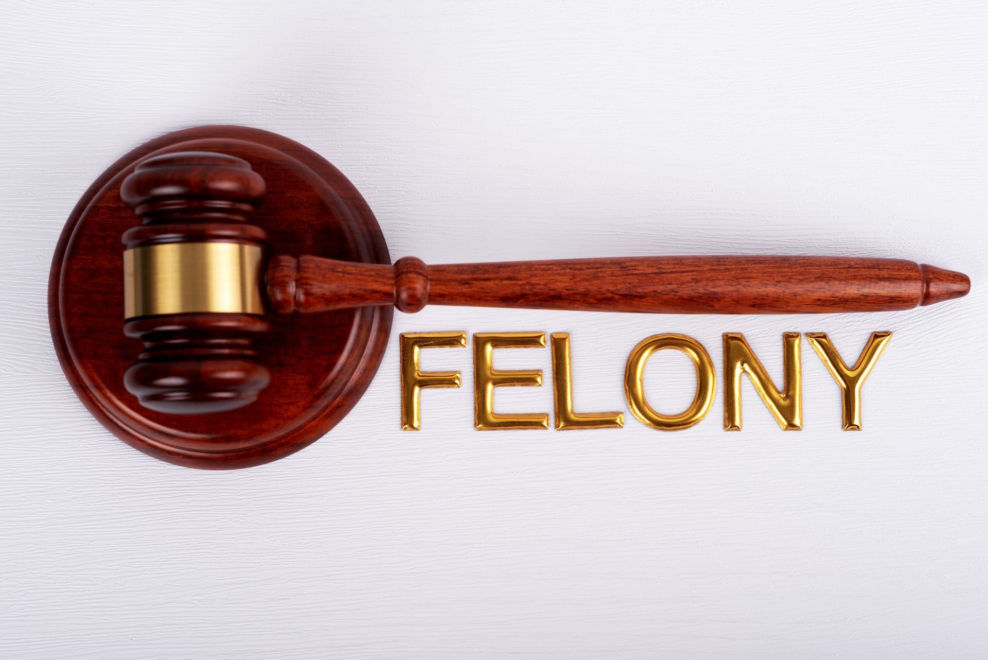 Judges gavel with the word “FELONY” in gold letters