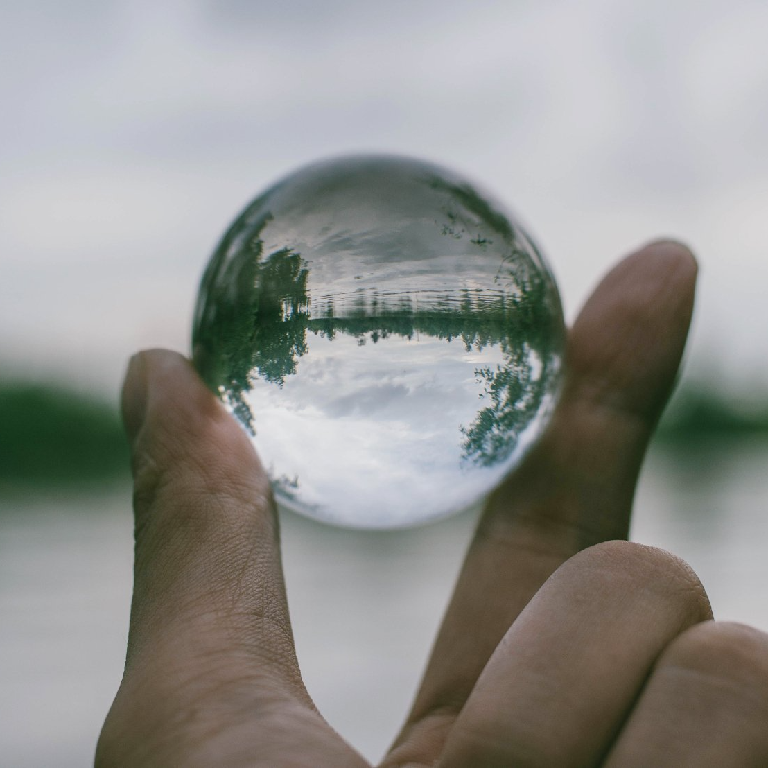 Zwei Finger, die eine Glaskugel halten: Sie und ihre Bedürfnisse sind unser Fokus.