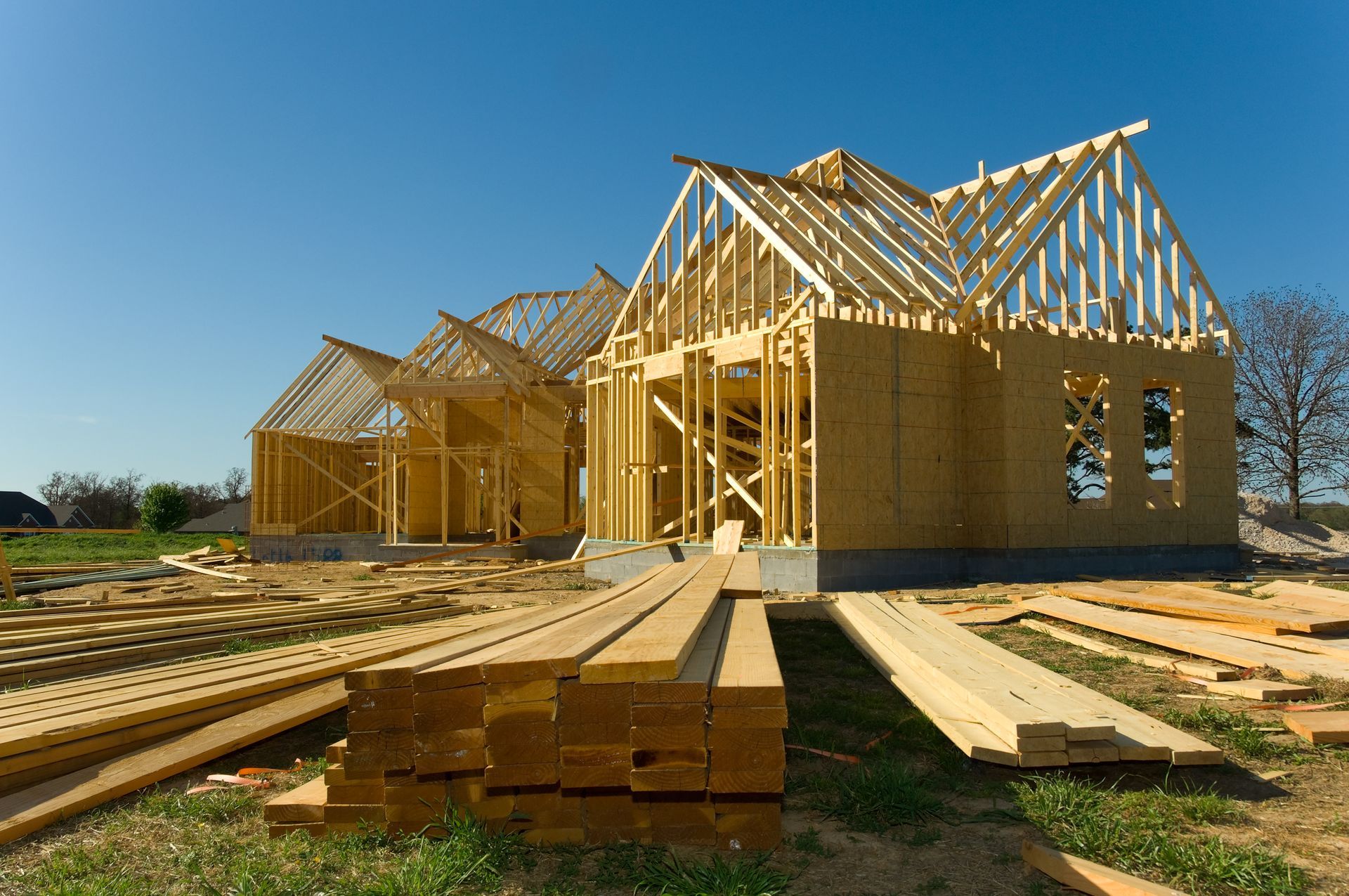 Une maison en construction avec beaucoup de bois devant