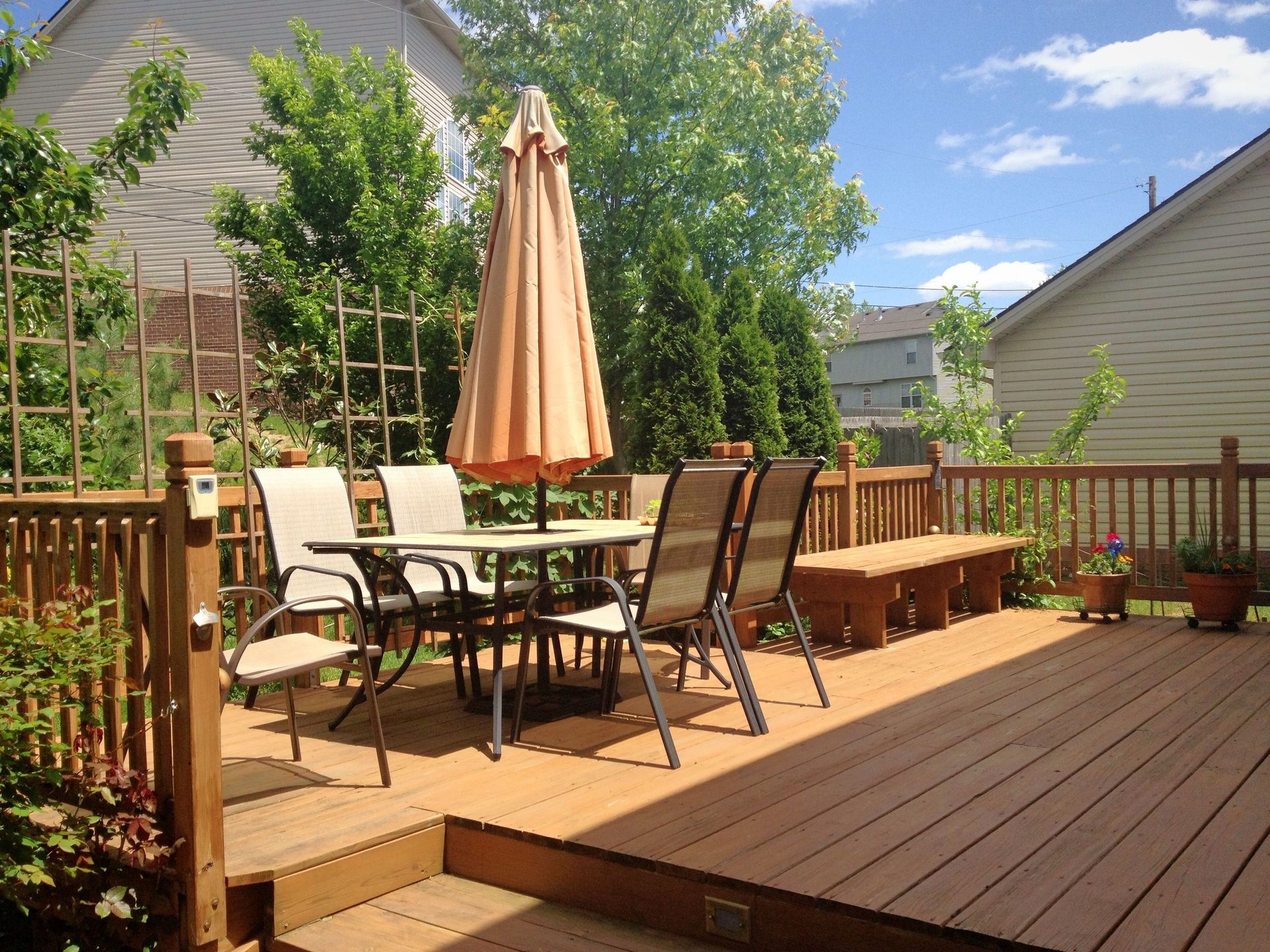 Une terrasse en bois avec une table, des chaises et un parasol