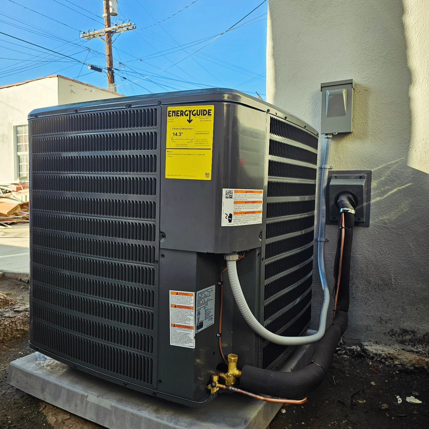 A black air conditioner with a yellow sticker that says 
