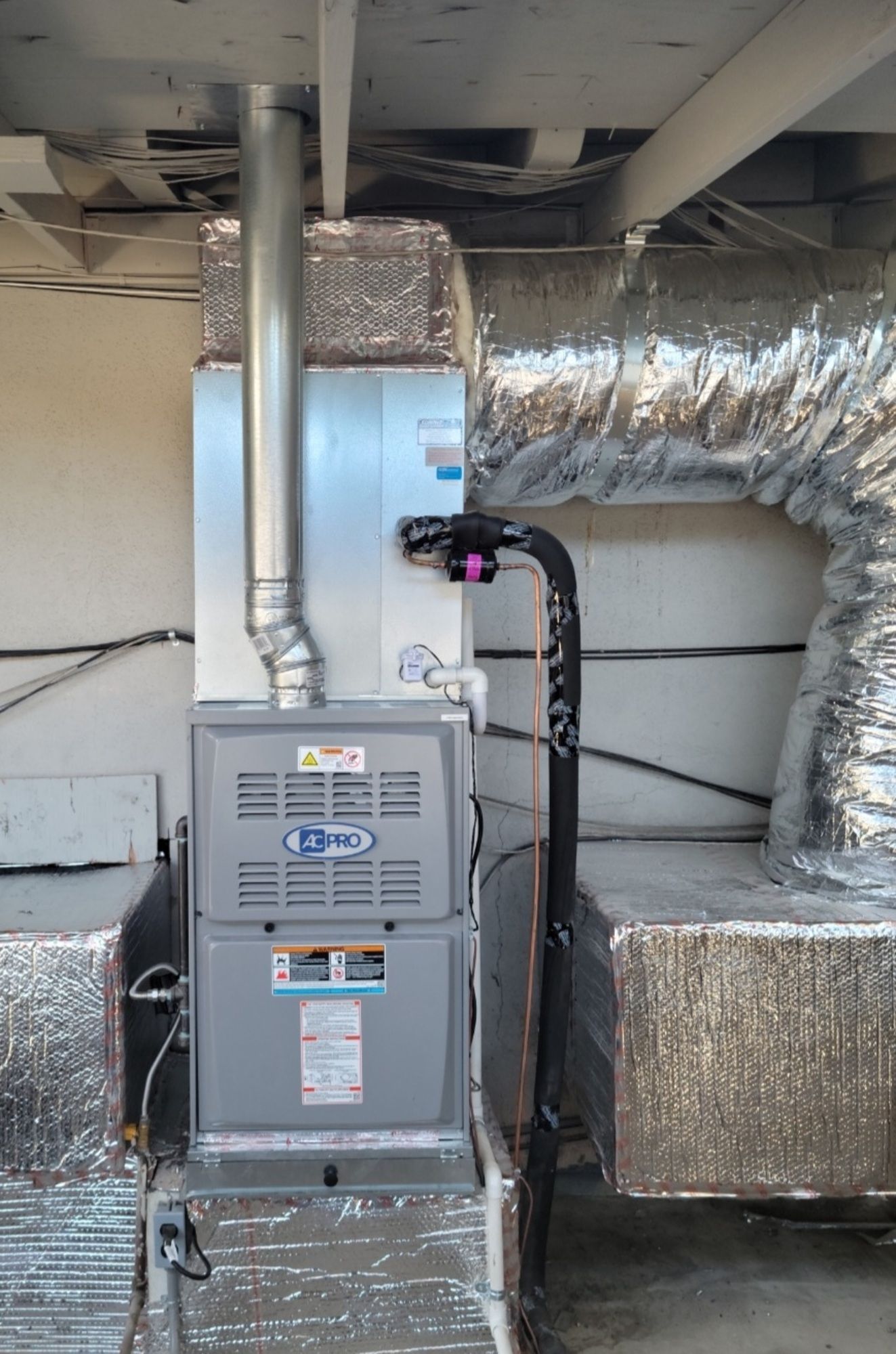 An air conditioner is sitting in a room next to a duct.