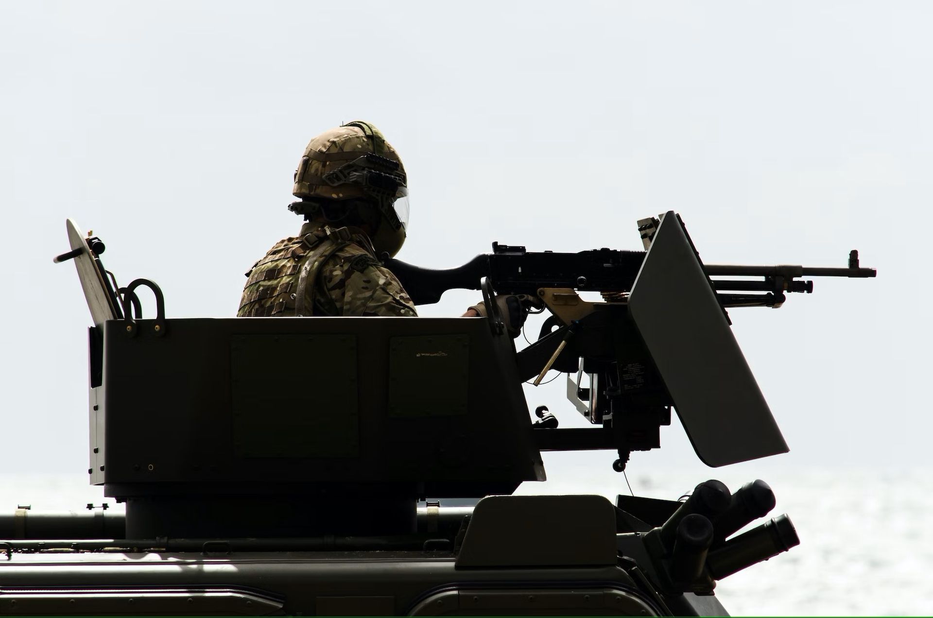 a gunner on top of a military vehicle