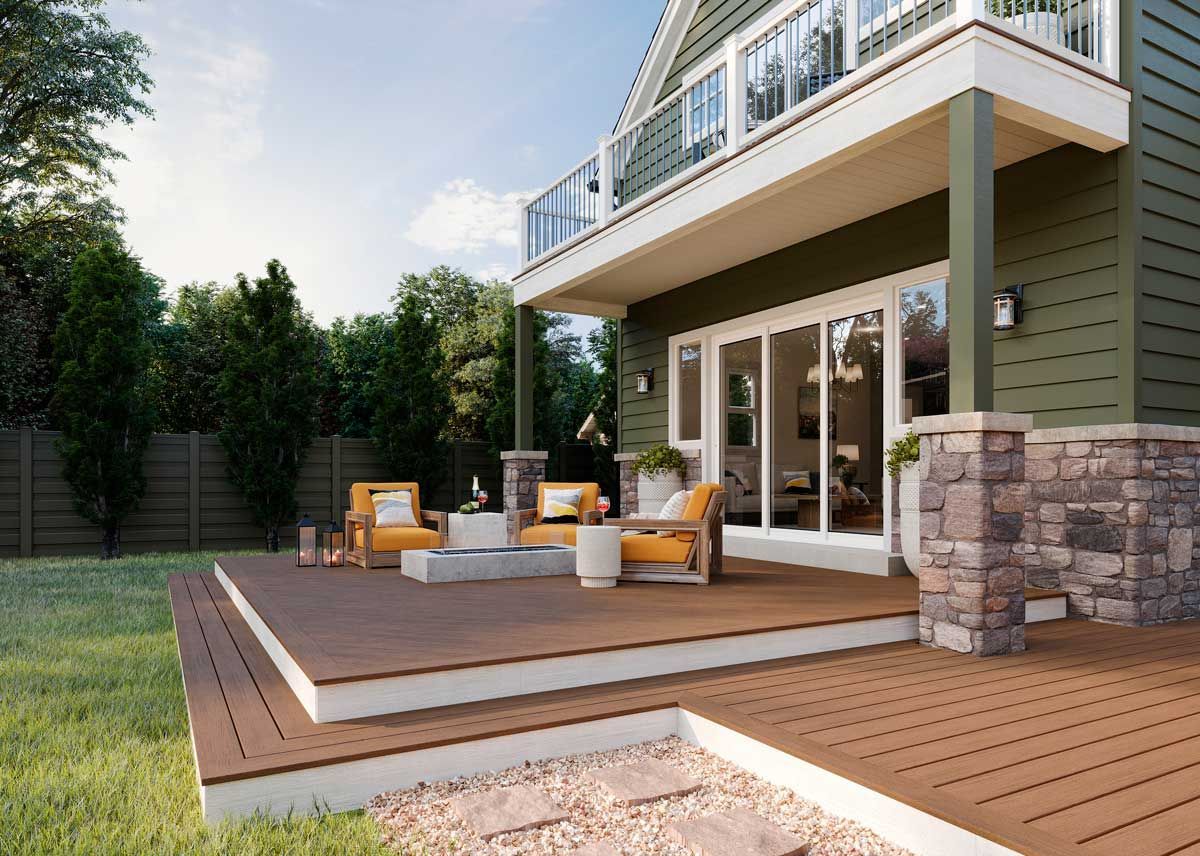 Trex® Decking from Budget Home Supply Colorado - Wooden deck and seating area outside a green house with a second-story balcony.