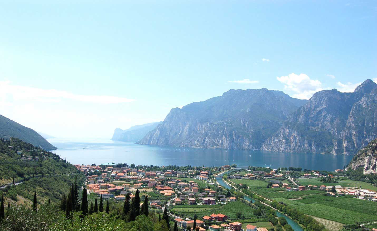 Lake Garda with vineyards, mountains, and a lakeside town.