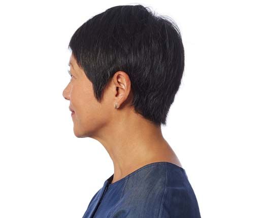 Woman with short, dark hair, in profile. She has a slightly hunched posture, wearing a blue shirt