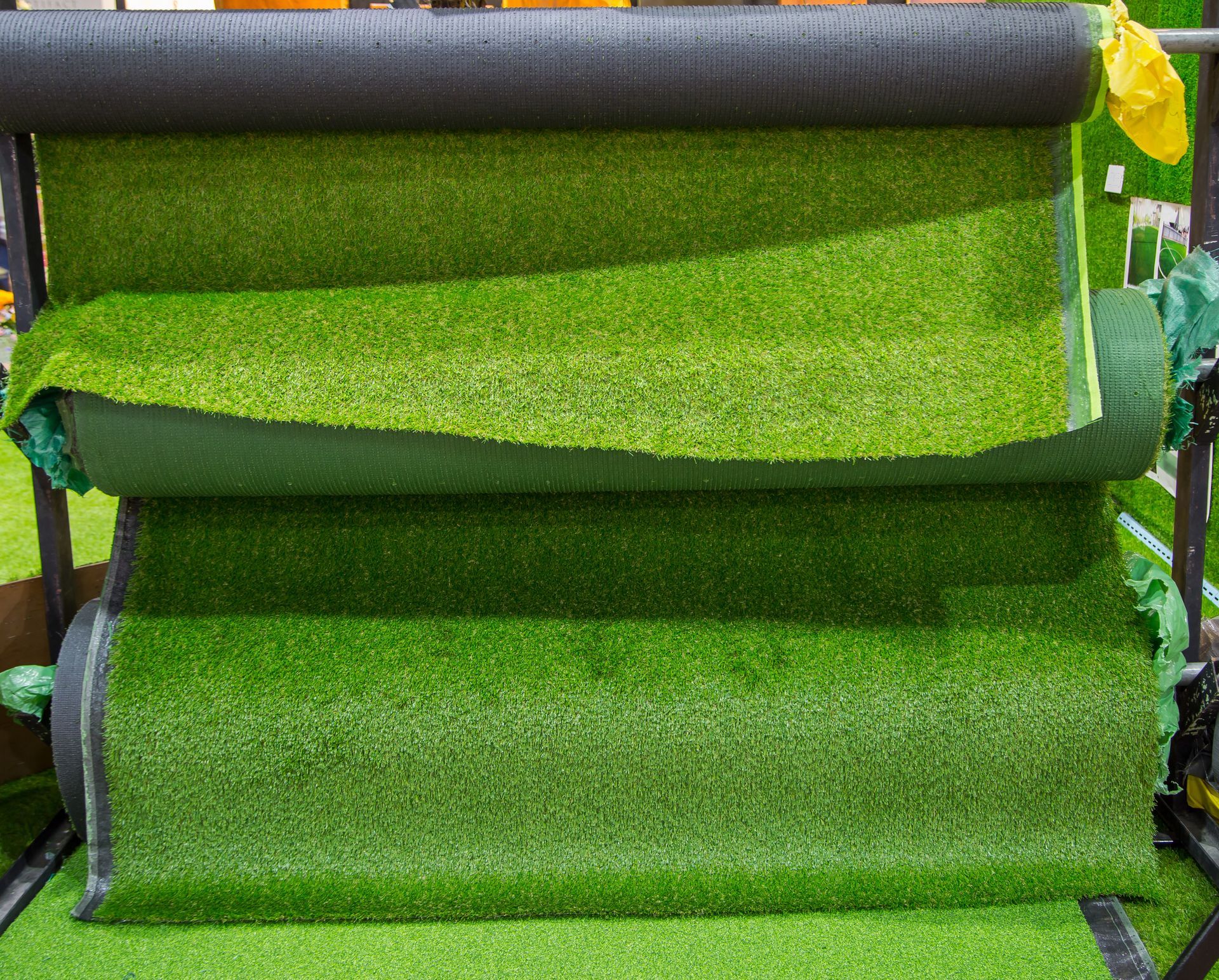 Green artificial turf being rolled through a machine during installation or processing