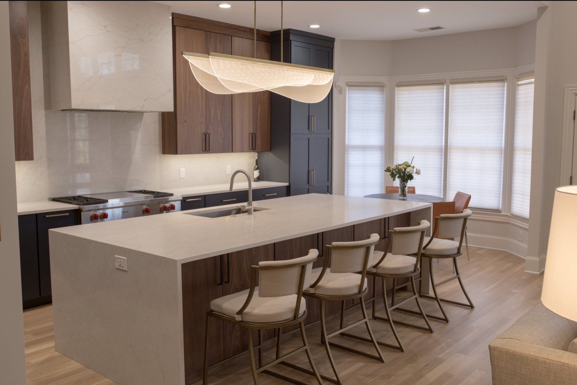 A kitchen with a large island and chairs in it