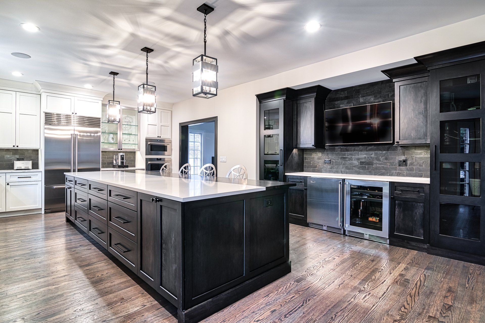 A kitchen with a large island in the middle and stainless steel appliances.