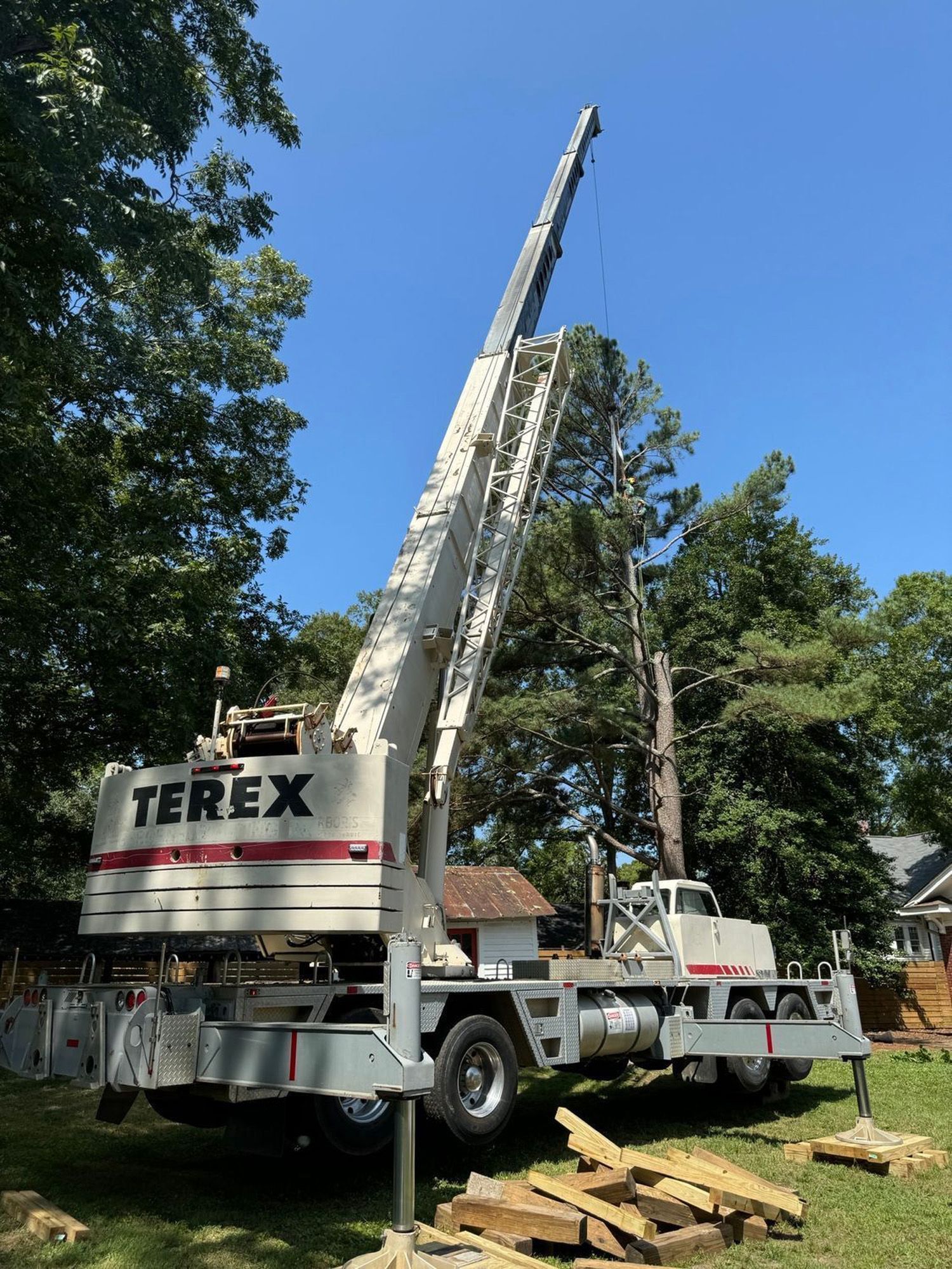 A terex crane is sitting on top of a truck in a yard.