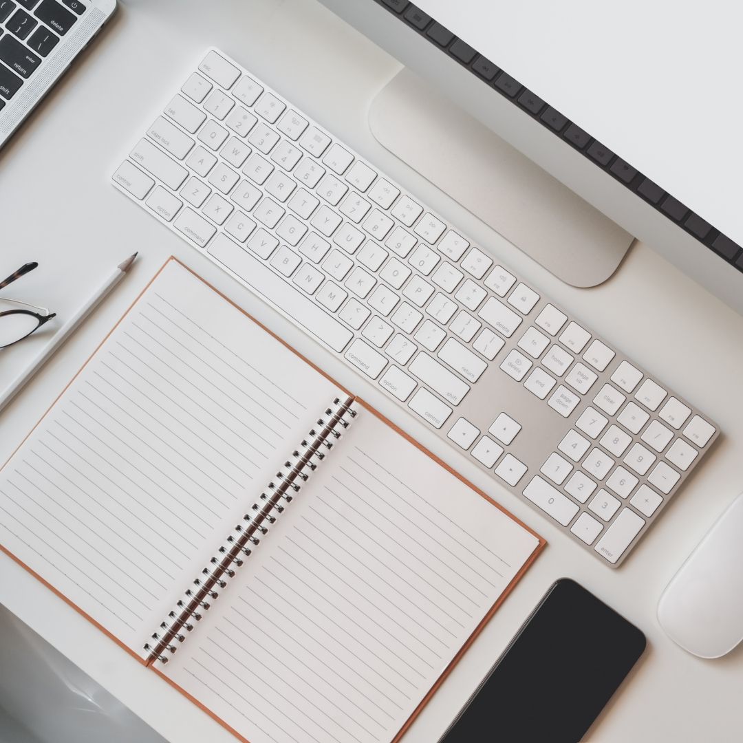 White Desk with A Keyboard, Notepad, Pen, Glasses, Phone, and Monitor — Slack-Smith Partners in Tamworth, NSW