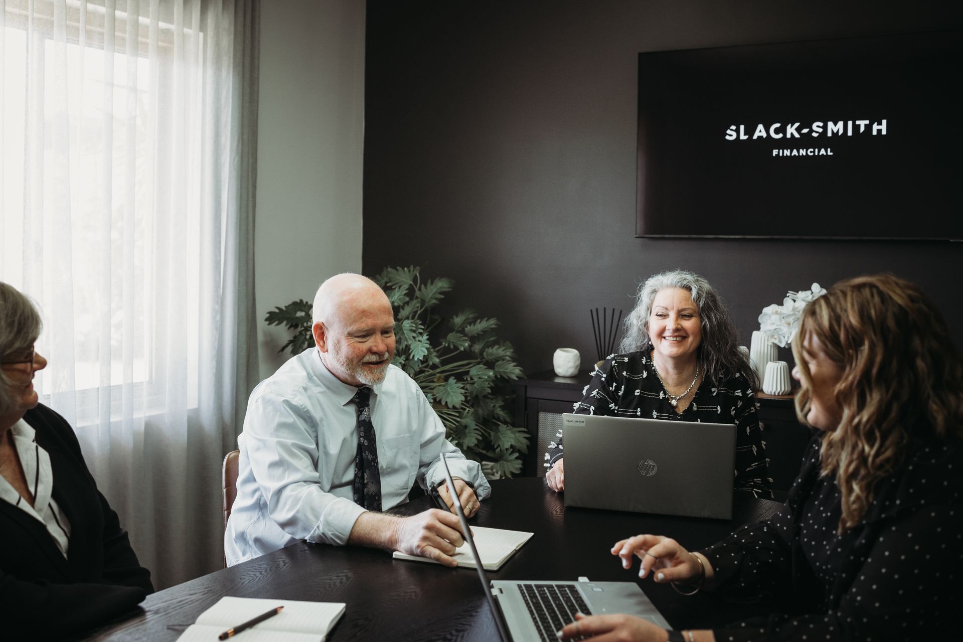 A Woman Is Sitting at A Desk Using a Laptop Computer — Slack-Smith Partners in Tamworth, NSW