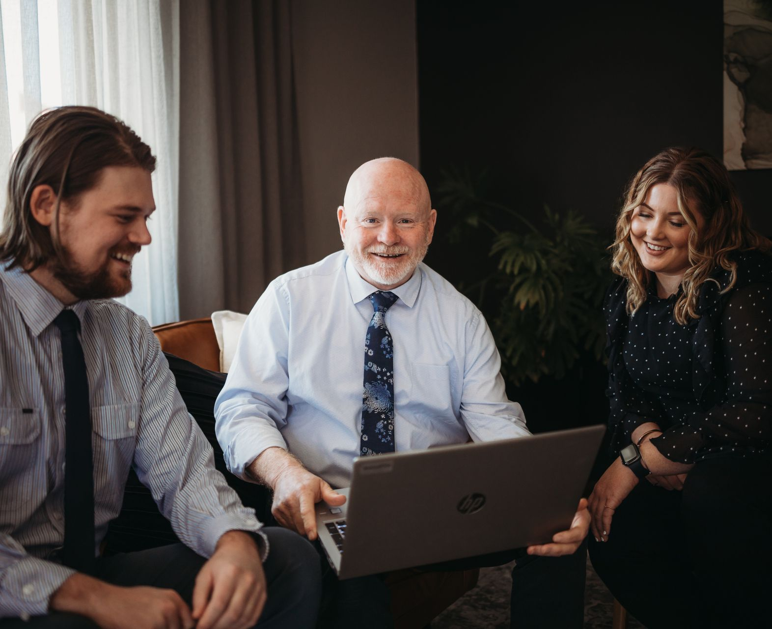 Three People Looking at a Laptop, Smiling — Slack-Smith Partners in Tamworth, NSW