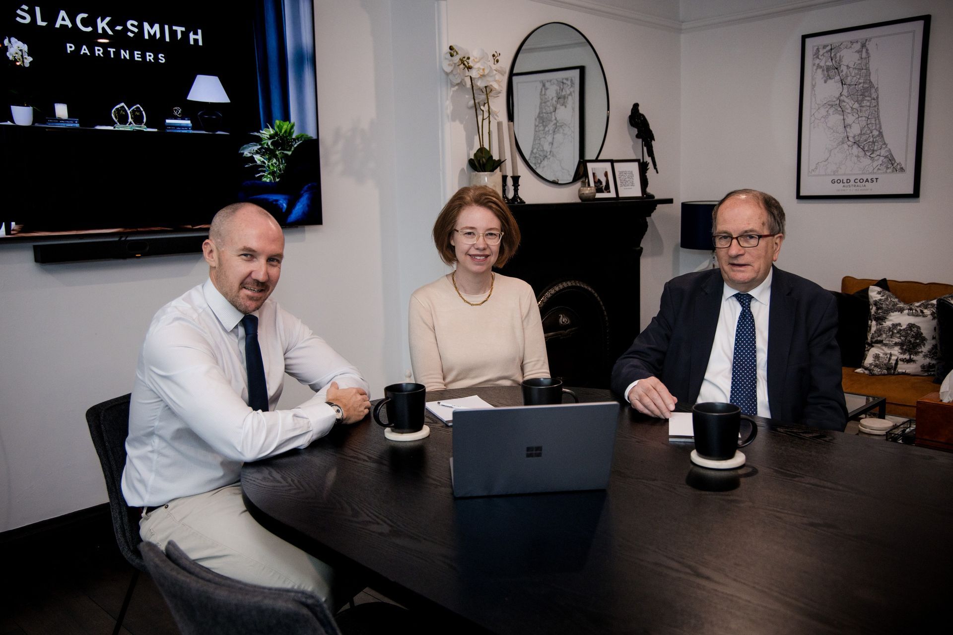 Two Men and a Woman Sitting at a Dark Table — Slack-Smith Partners in Tamworth, NSW