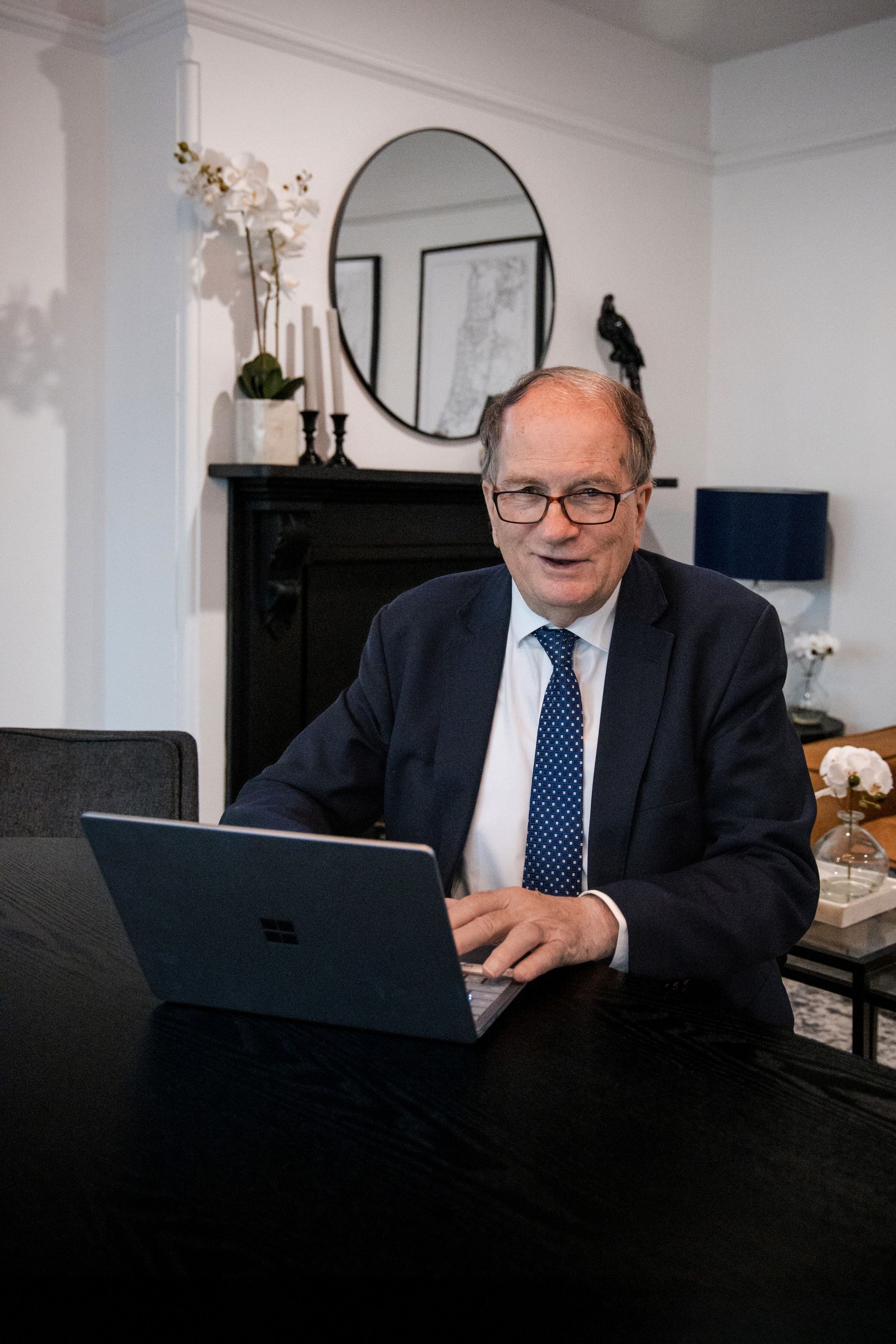 Man in Suit at a Desk, Looking at a Laptop. Sitting in Front of a Fireplace — Slack-Smith Partners in Tamworth, NSW
