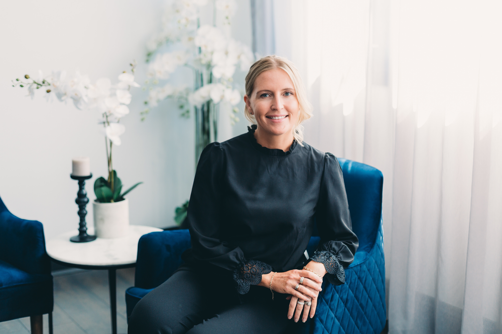 A Woman in A Black Shirt is Sitting in A Blue Chair — Slack-Smith Partners in Tamworth, NSW