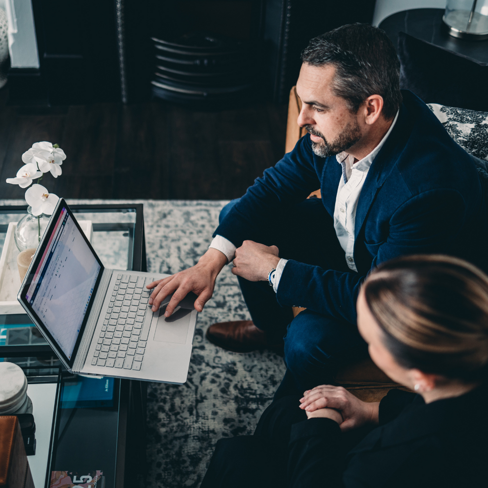 A Man and A Woman Are Sitting in Front of A Laptop Computer — Slack-Smith Partners in Tamworth, NSW