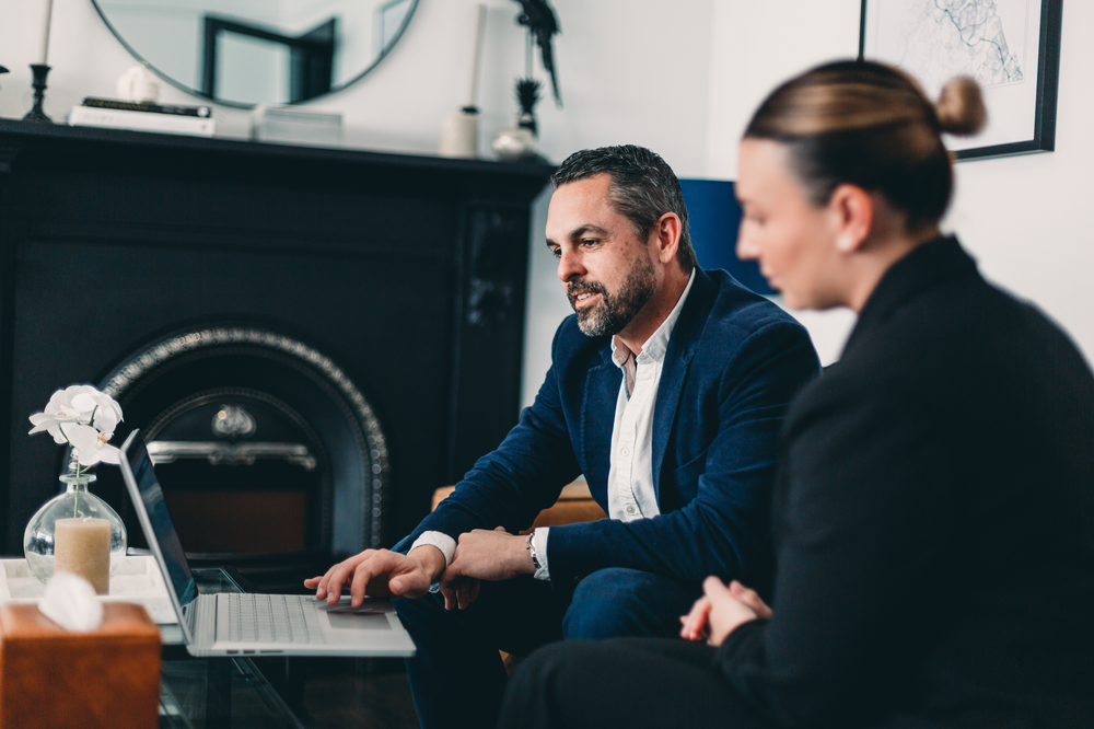 A Man and A Woman Are Sitting in Front of A Laptop Computer — Slack-Smith Partners in Tamworth, NSW