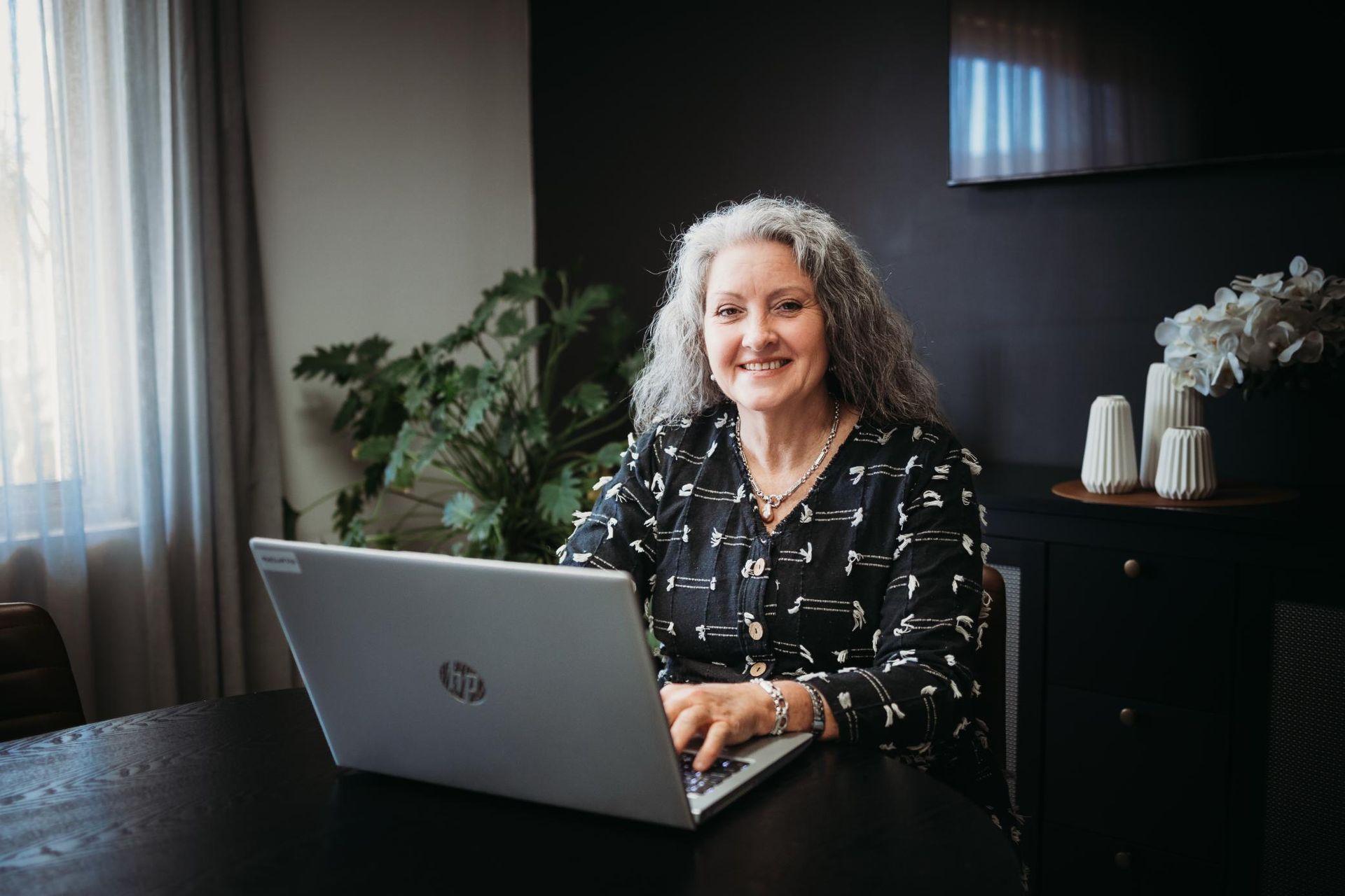 Woman is Sitting at a Table Using a Laptop Computer — Slack-Smith Partners in Tamworth, NSW