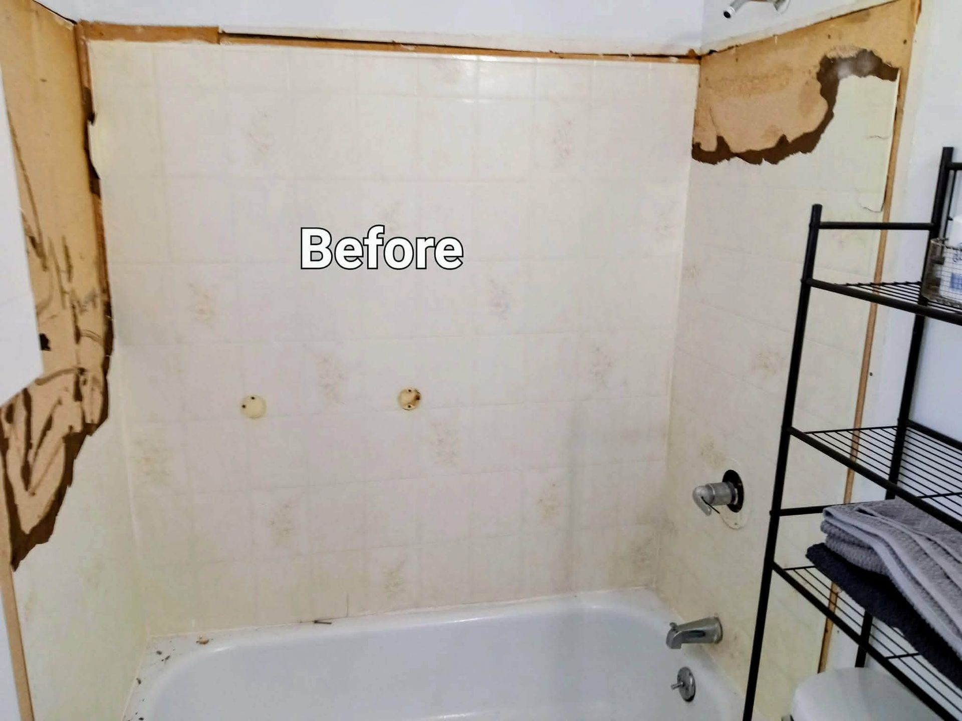 Before photo of a worn bathroom with peeling walls, a bathtub, and a metal shelf