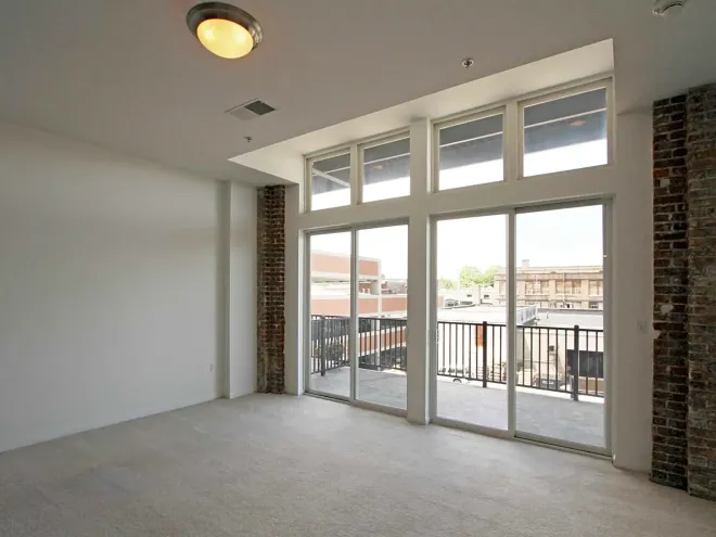 An empty room with lots of windows and a balcony
