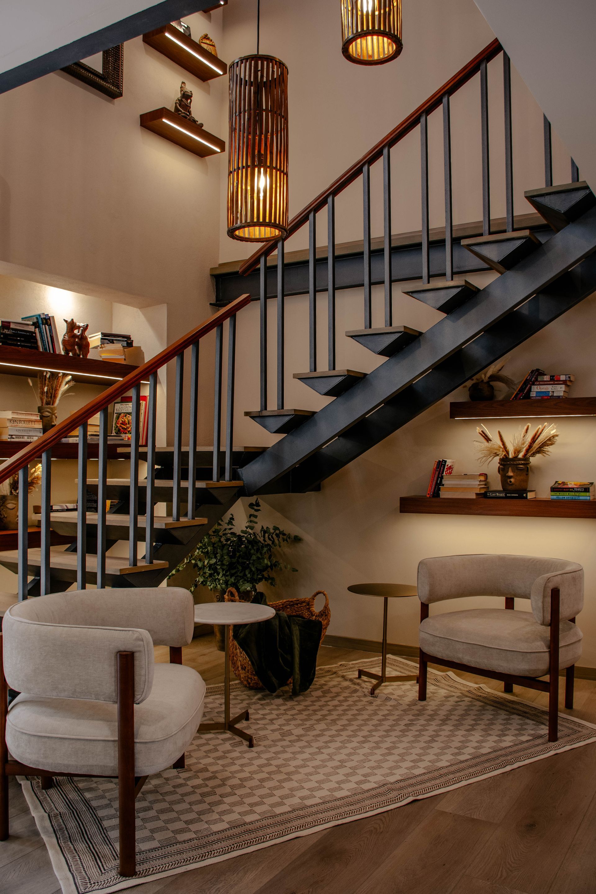 Escalera moderna y acogedora zona de asientos con cálidas lámparas colgantes y detalles de madera