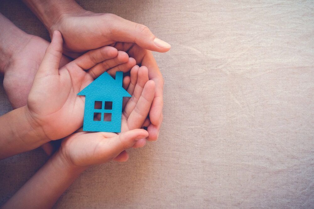 A Man and a Child Are Holding a Blue House in Their Hands — Murphy Finance Solutions In Zuccoli, NT