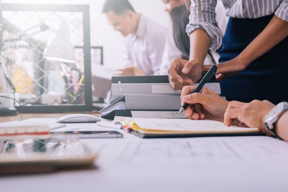 A Group of People Are Sitting at a Table Working on a Project — Murphy Finance Solutions In Zuccoli, NT