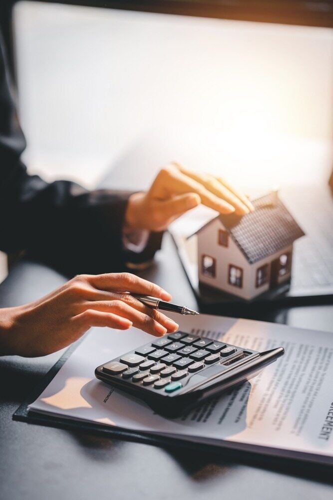 A Person is Using a Calculator to Calculate the Cost of a House — Murphy Finance Solutions In Zuccoli, NT