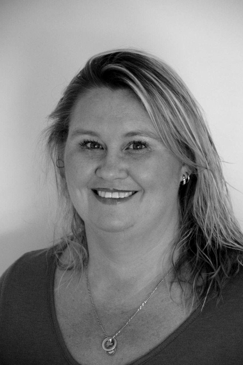 Smiling woman with blonde hair wearing a dark top and necklace against a plain background — Murphy Finance Solutions In Zuccoli, NT