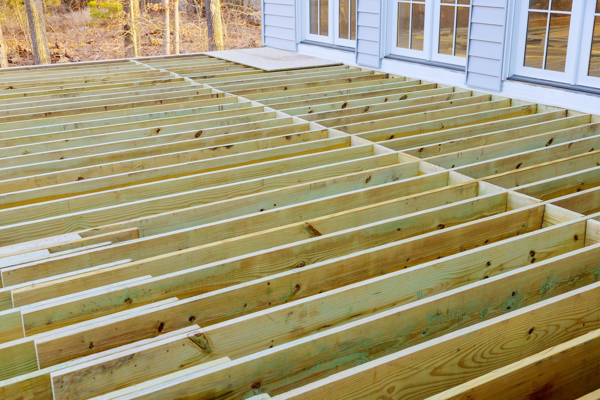 Charpente de terrasse en bois en construction, avec poutres horizontales.