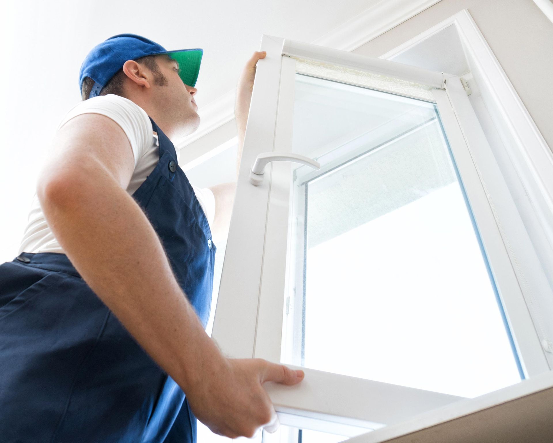 A man is installing a window in a house.