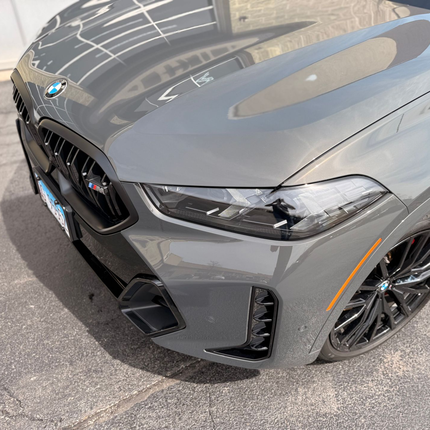 Gray BMW sports car parked at an angle on a street, showing the front-left side.