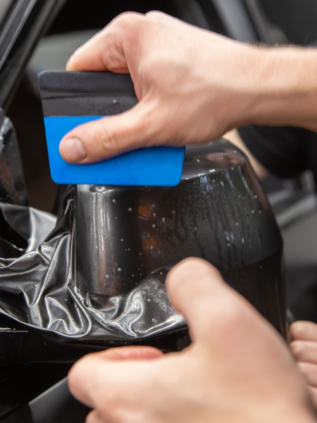 A person is washing a car wheel with foam