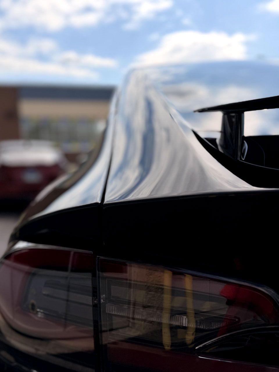 A person is applying a clear film to the hood of a car.